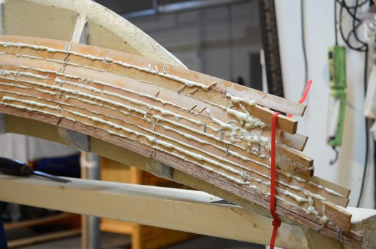 The swept bow and stern creates clamping challenges but splitting the strips over the curved portion with a utility knife is a great help.